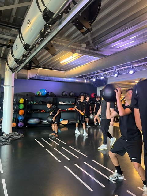 Een groep voetballers van NAC die de oefening Wall Balls aan het uitvoeren zijn.