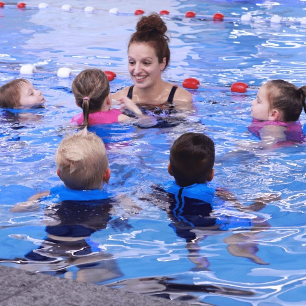 Een zwemdocent die zwemles geeft aan een groep kinderen